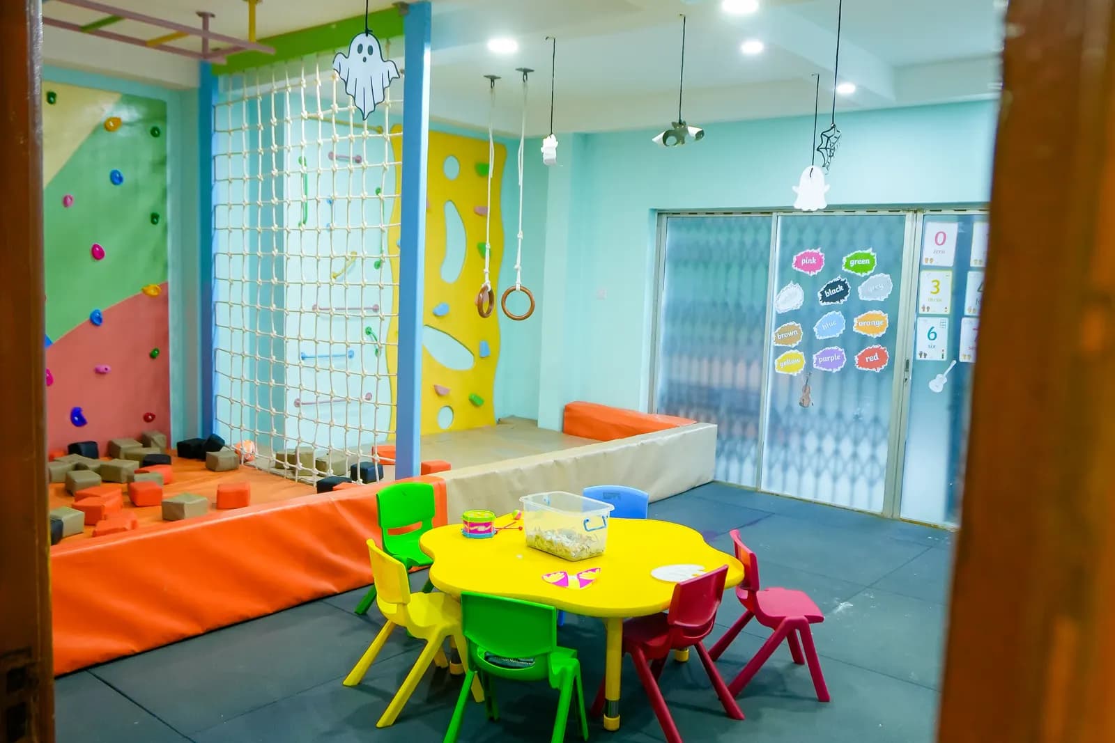 The Daydreams climbing room, with a climbing wall, cargo net and a children's table