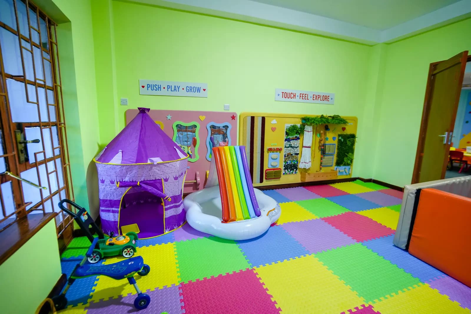 A rainbow slide and sensory boards in the Daydreams soft-play room