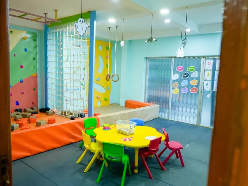 The Daydreams climbing room, with a climbing wall, cargo net and a small table and chairs