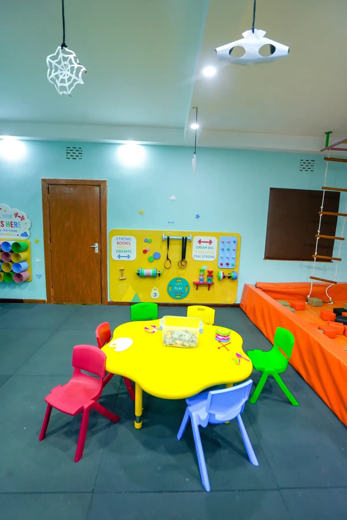 Little chairs around a yellow activity table set up for crafts